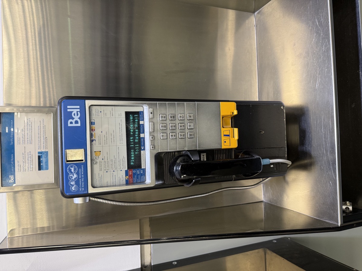 A vintage Bell payphone displaying 'Please lift receiver'